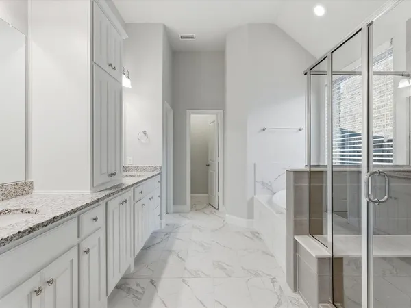 a spacious bathroom with a granite countertop sink mirror and shower