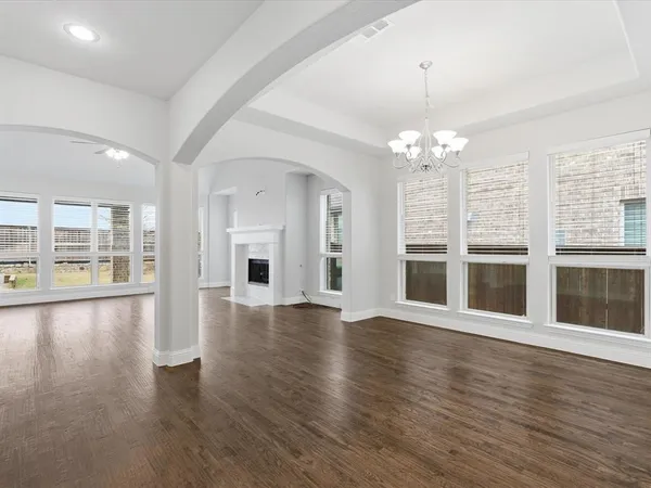 a view of an empty room with wooden floor and a large window