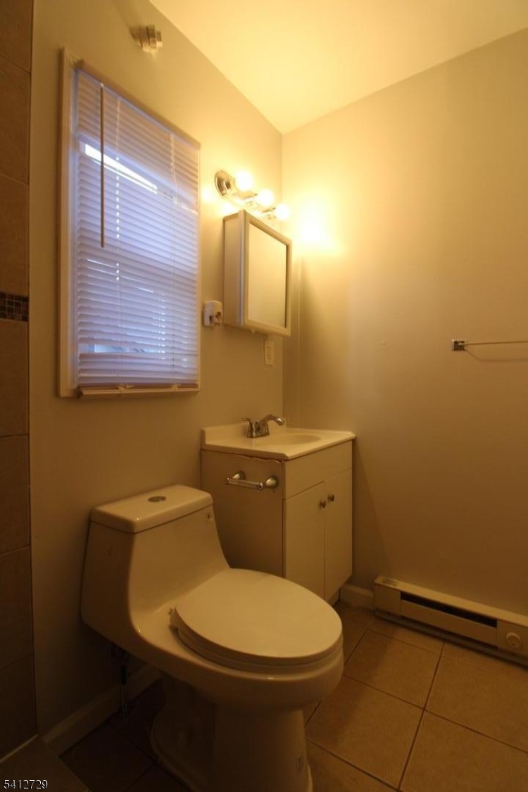 196 Shephard Avenue, Unit 3 Newark, NJ 07112 - Photo 11 of 12 a bathroom with a toilet sink and mirror