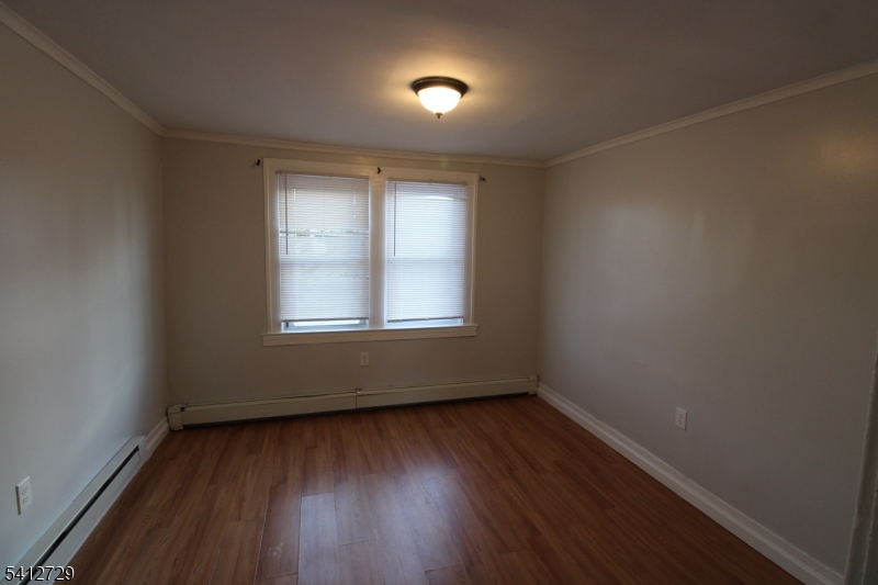 196 Shephard Avenue, Unit 3 Newark, NJ 07112 - Photo 2 of 12 an empty room with wooden floor and windows