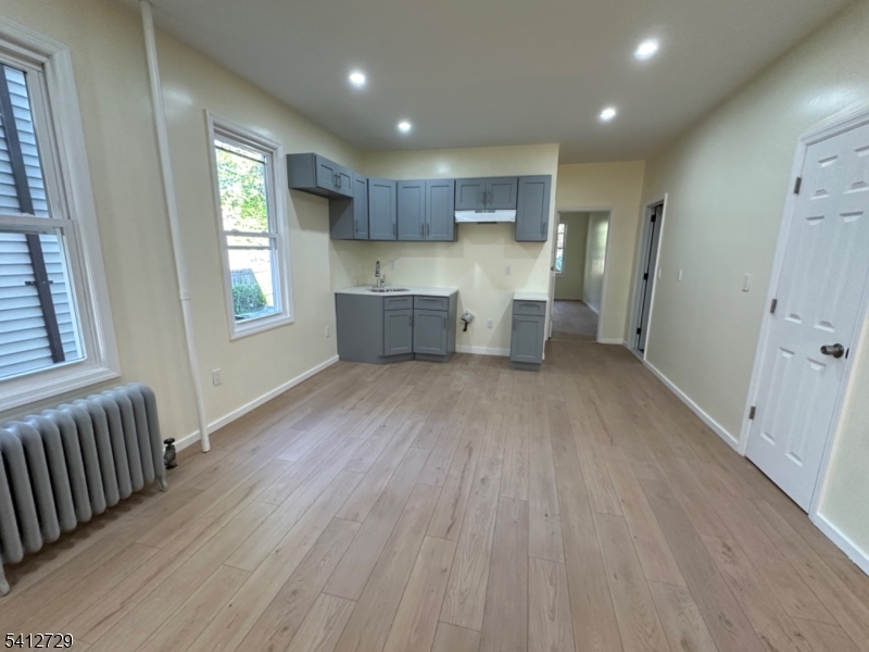 22 Cummings Street, Unit 3 Irvington, NJ 07111 - Photo 3 of 7 a kitchen with stainless steel appliances refrigerator wooden floor and window