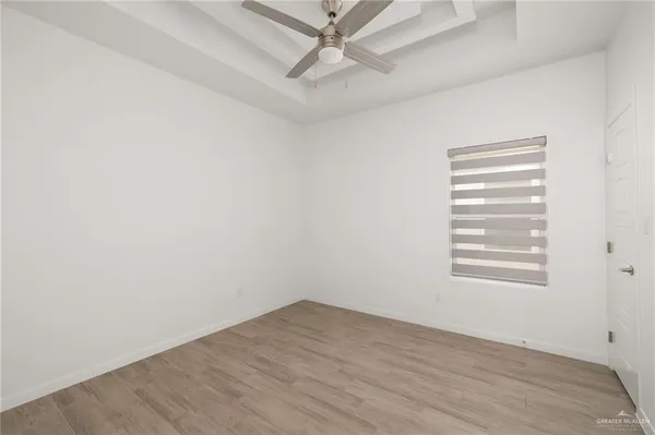 an empty room with a window and wooden floor