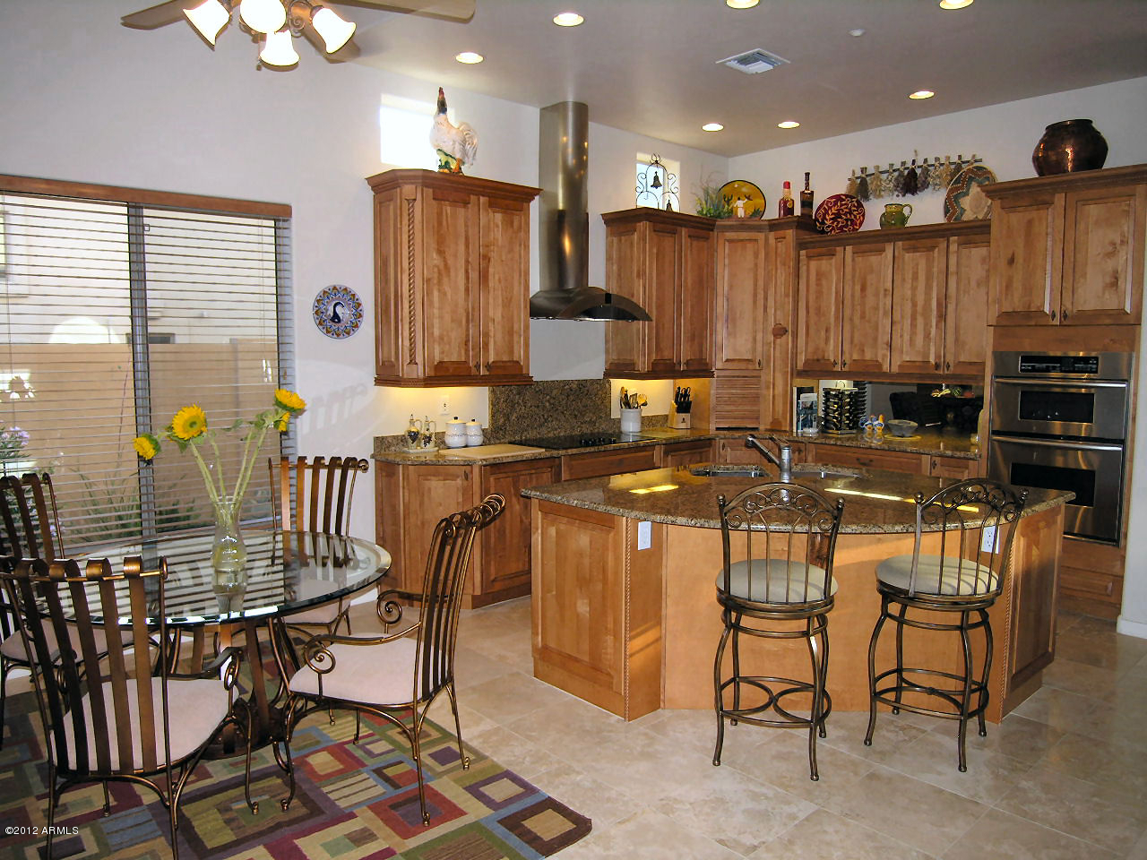 a kitchen with stainless steel appliances kitchen island granite countertop a table and chairs