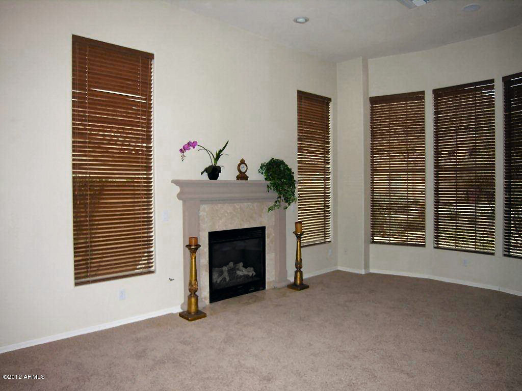 11517 East Ranch Gate Road Scottsdale, AZ 85255 - Photo 3 of 35 a view of an empty room with a fireplace and windows