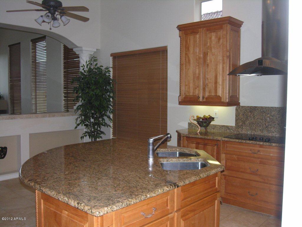 11517 East Ranch Gate Road Scottsdale, AZ 85255 - Photo 9 of 35 a kitchen with granite countertop a sink a stove and a wooden cabinets