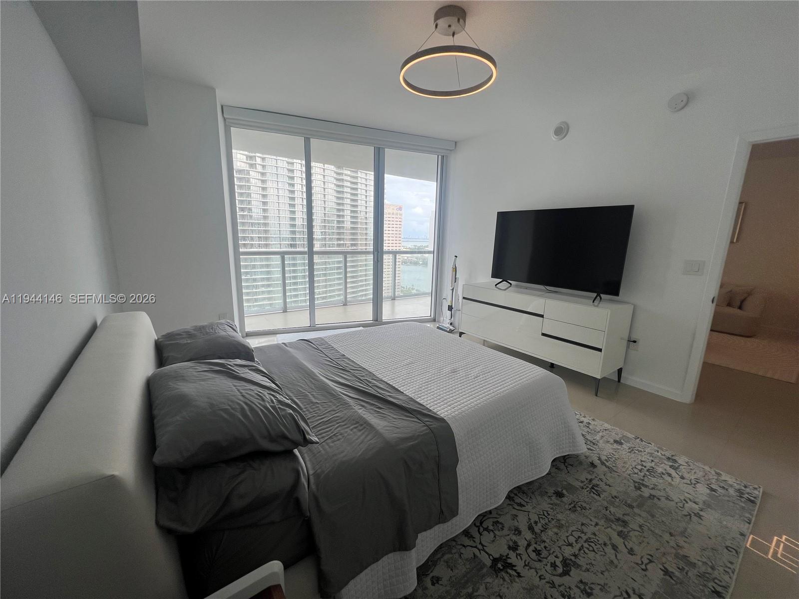475 Brickell Avenue, Unit 3514 Miami, FL 33131 - Photo 3 of 16 a bedroom with a bed and a flat tv screen on wall