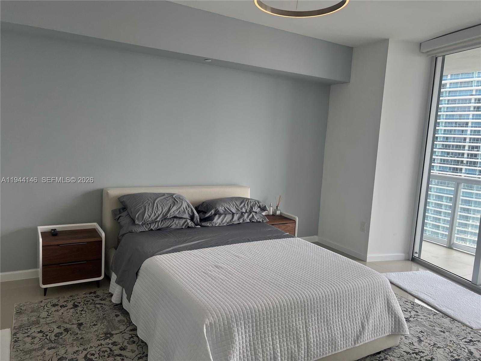 475 Brickell Avenue, Unit 3514 Miami, FL 33131 - Photo 4 of 16 a bedroom with a bed and wooden floor