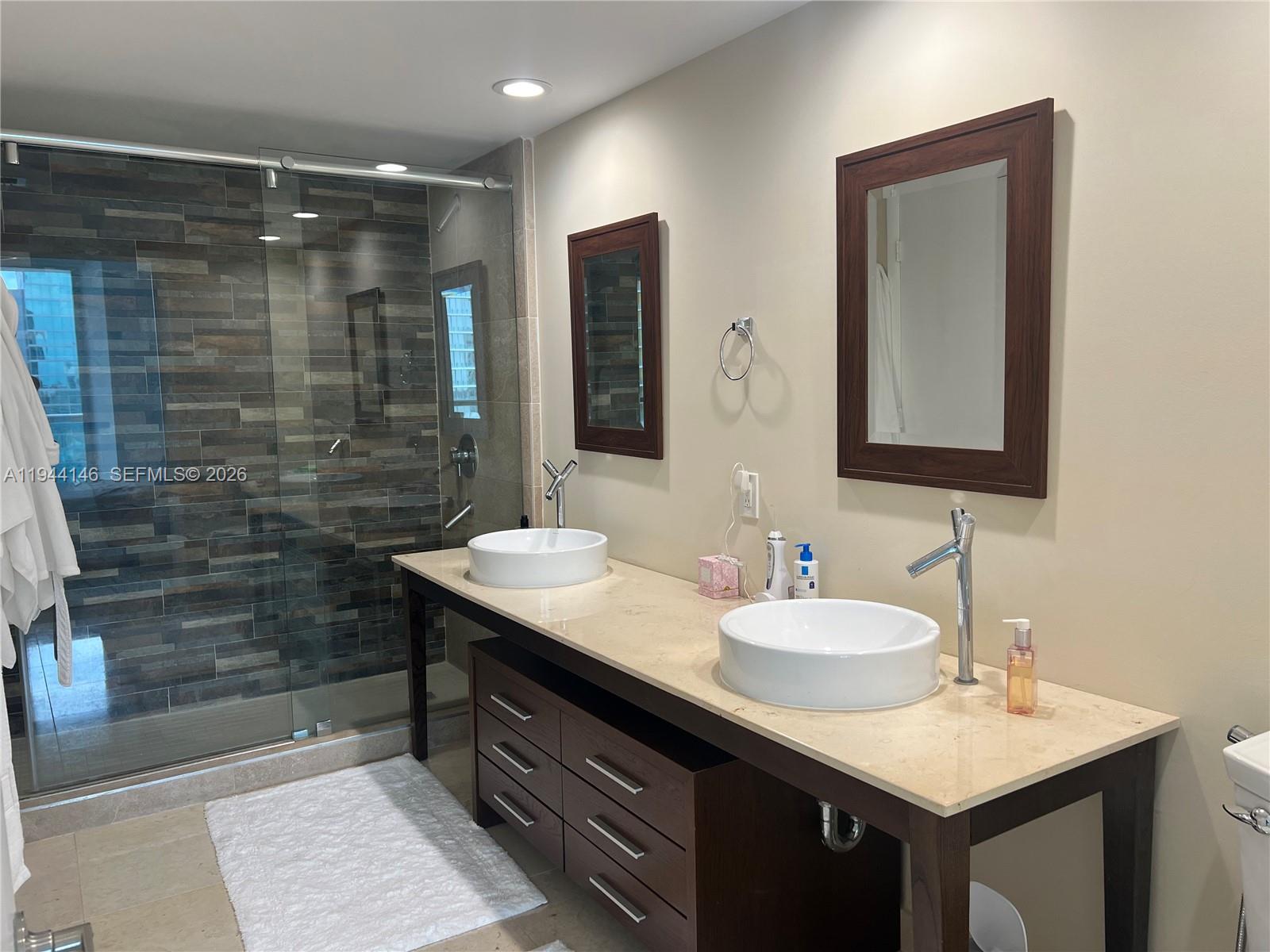 475 Brickell Avenue, Unit 3514 Miami, FL 33131 - Photo 8 of 16 a bathroom with a sink vanity granite shower and a mirror