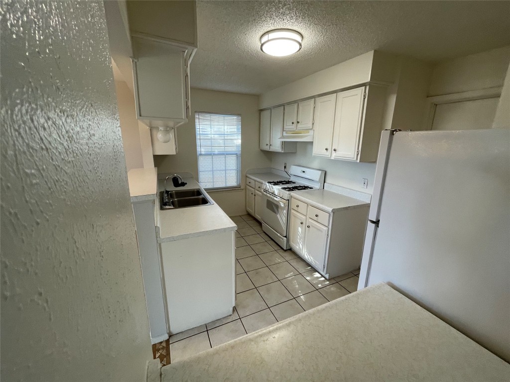 12013 Swallow Drive Austin, TX 78750 - Photo 12 of 25 a kitchen with a stove and a refrigerator
