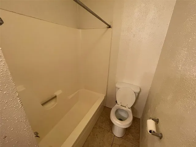 a bathroom with a granite countertop toilet and a sink