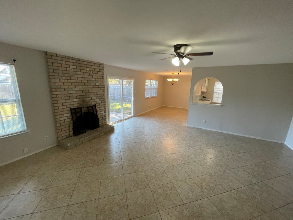 12013 Swallow Drive Austin, TX 78750 - Photo 7 of 25 a view of a livingroom with a fireplace a ceiling fan and windows