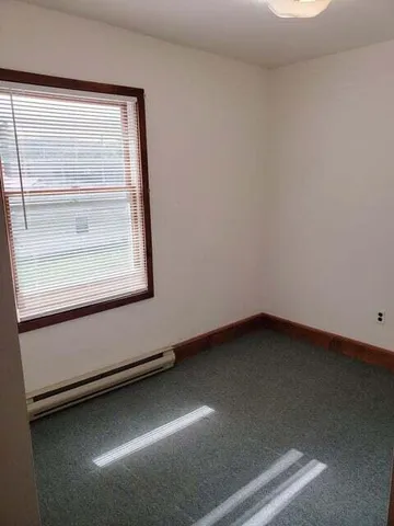a view of a small space with wooden floor and a window