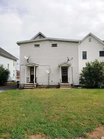 a big house with a yard and a large tree