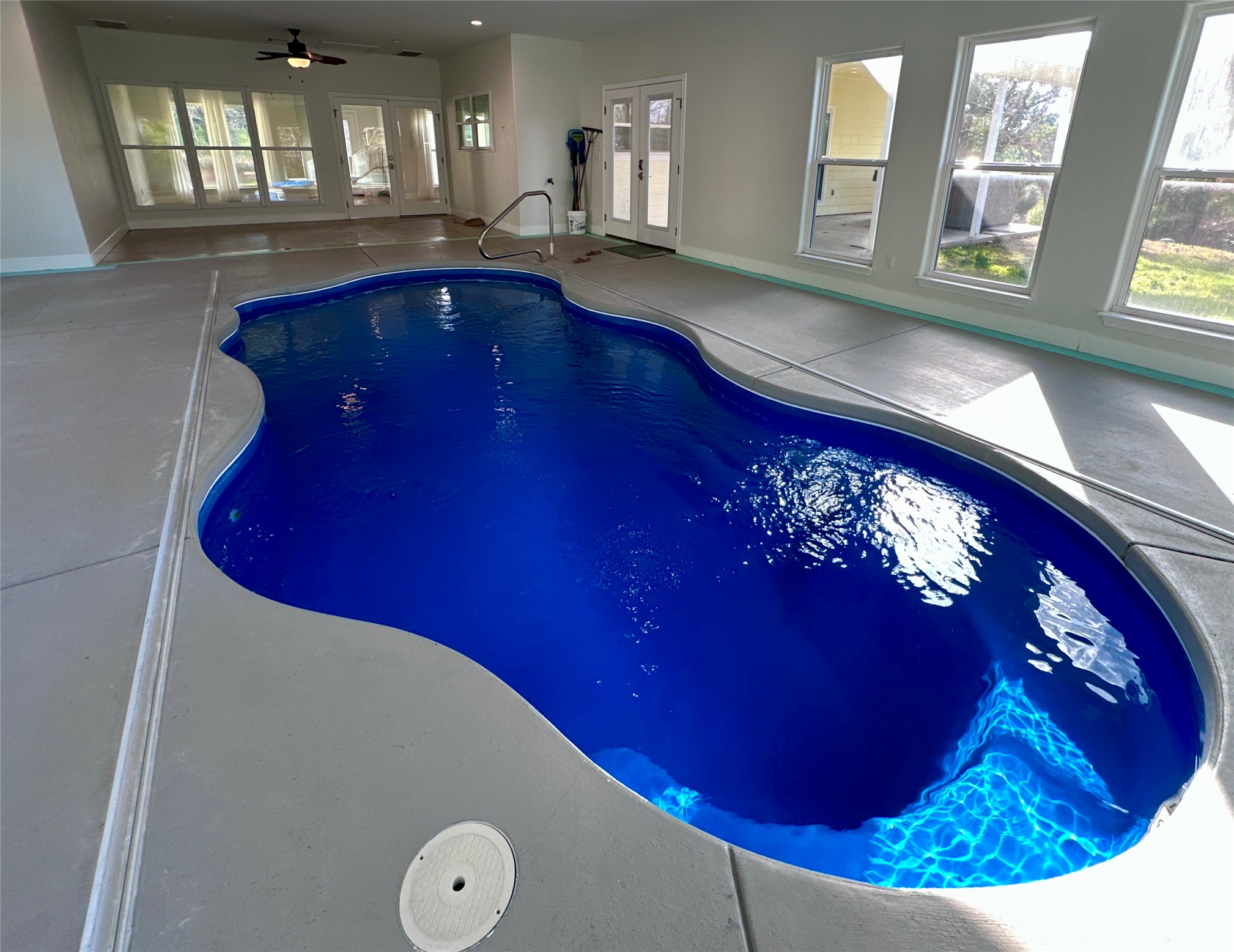 124 Pine Path Bastrop, TX 78602 - Photo 2 of 31 View of swimming pool with a hot tub and french doors. Heated and cooled room.