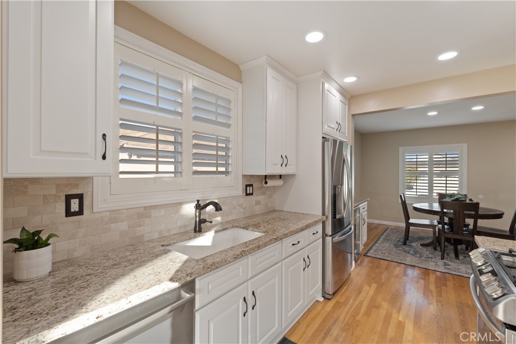 4559 Levelside Avenue Lakewood, CA 90712 - Photo 17 of 32 a kitchen with granite countertop a sink appliances dining table and chairs