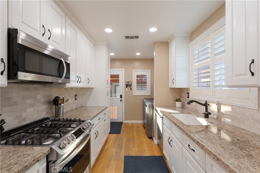 4559 Levelside Avenue Lakewood, CA 90712 - Photo 18 of 32 a kitchen with stainless steel appliances granite countertop a sink a stove oven a counter space and cabinets