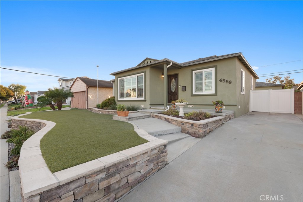 4559 Levelside Avenue Lakewood, CA 90712 - Photo 4 of 32 a front view of a house with a garden and patio