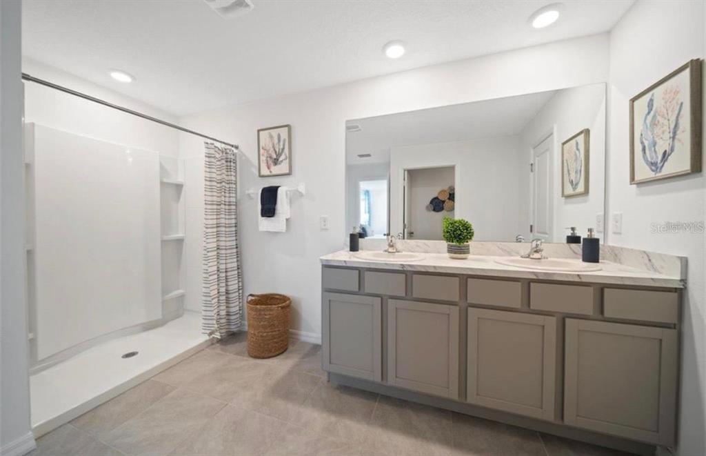 16716 Glacier Bay Loop Wimauma, FL 33598 - Photo 6 of 10 a spacious bathroom with double sink and a mirror