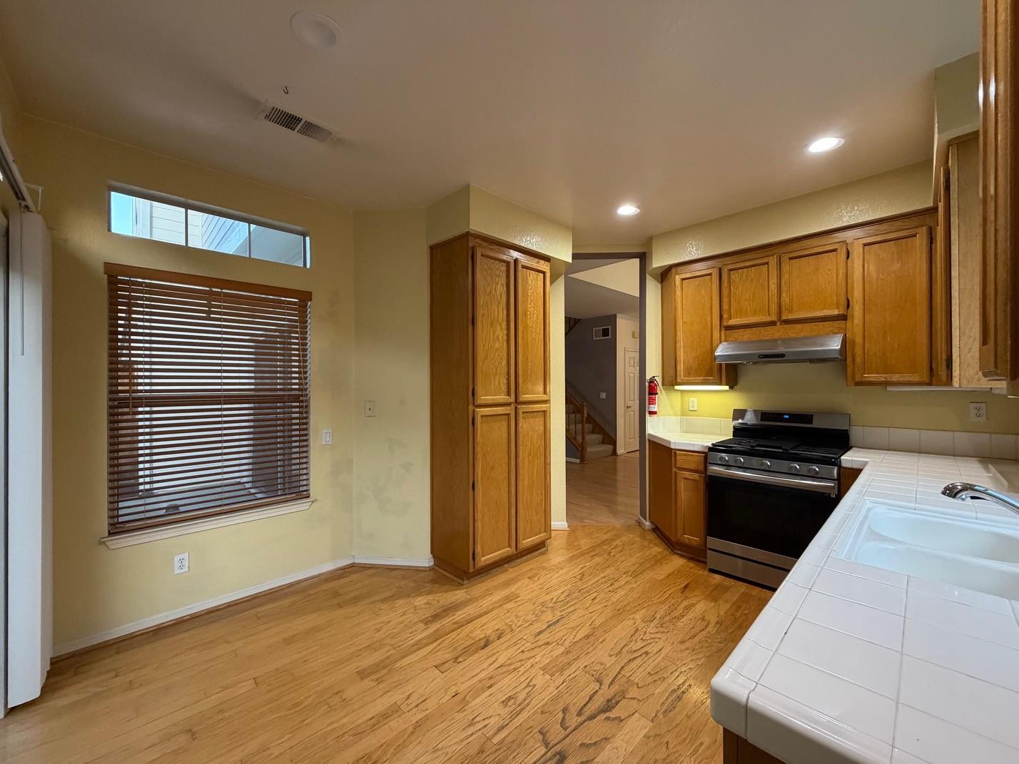 5417 Ridgewood Drive Fremont, CA 94555 - Photo 16 of 36 a kitchen with stainless steel appliances granite countertop a refrigerator a sink dishwasher a stove and a refrigerator with wooden floor