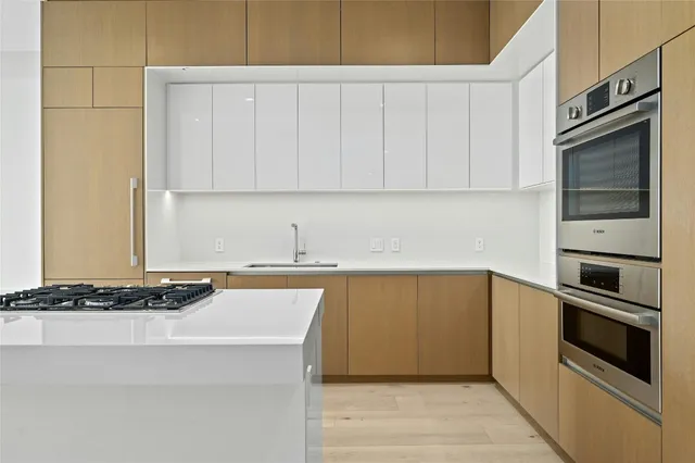 a kitchen with stainless steel appliances a sink stove and cabinets