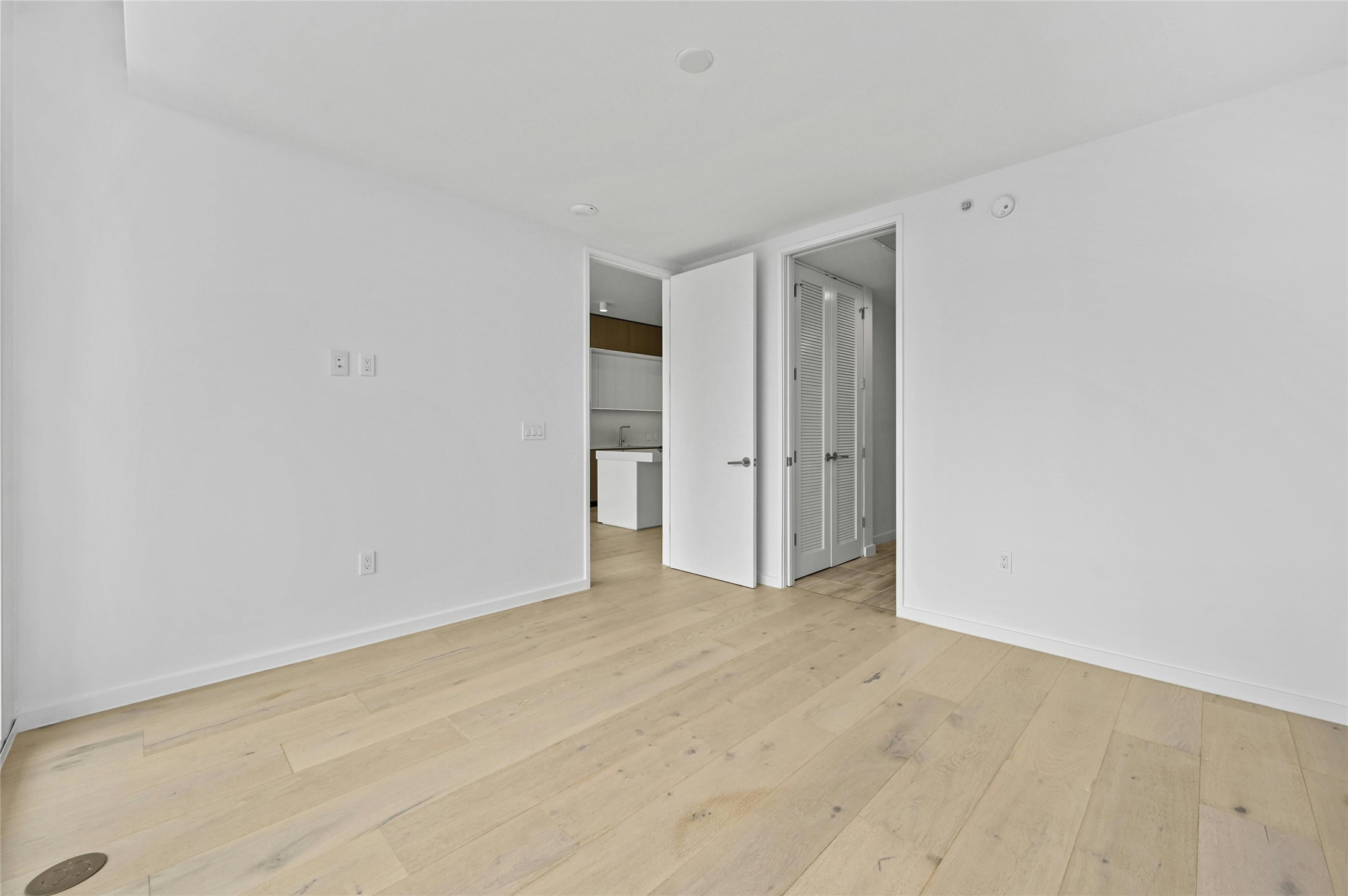 313 West 17th Street, Unit 2103 Austin, TX 78701 - Photo 9 of 39 The primary suite offers wide-plank oak floors, clean modern lines, and space for a king-size bed. A walk-in closet provides ample storage with double hanging rods and shelving. The ensuite bath features a soaking tub and shower with floor-to-ceiling tile, recessed niches, and sleek modern fixtures for a spa-like retreat.