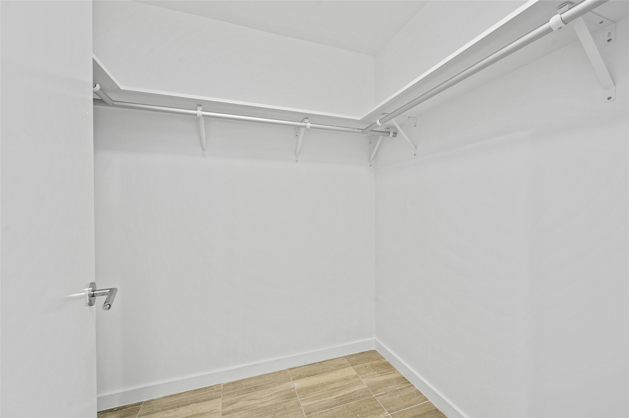 313 West 17th Street, Unit 2103 Austin, TX 78701 - Photo 11 of 39 Generous walk-in closet with built-in shelving and double hanging rods, offering abundant storage and organization for a primary wardrobe.