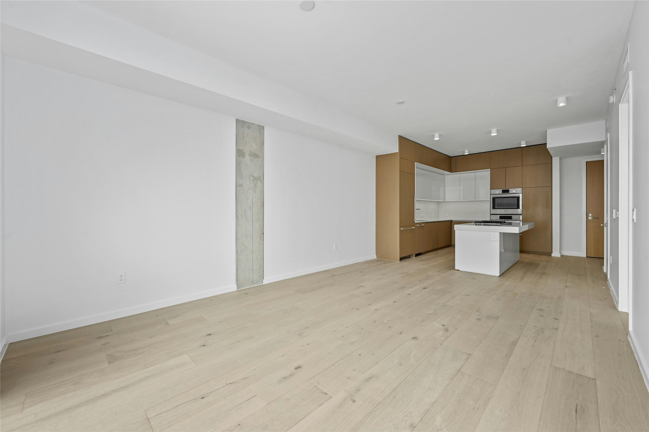 313 West 17th Street, Unit 2103 Austin, TX 78701 - Photo 7 of 39 Spacious open-plan living and dining area with wide-plank oak floors and clean modern lines. The kitchen, designed by Rhode Partners, features a Silestone® island, integrated Bosch® appliances, and custom cabinetry—perfectly blending functionality with style.