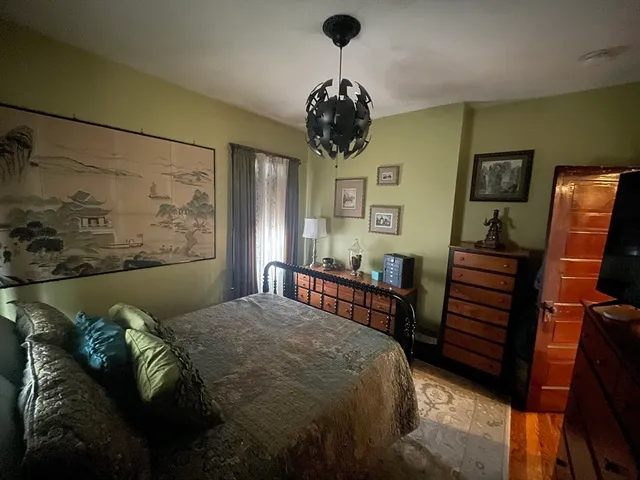 a bedroom with a bed and a chandelier