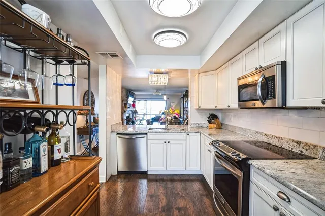 a kitchen with stainless steel appliances granite countertop a stove and a sink