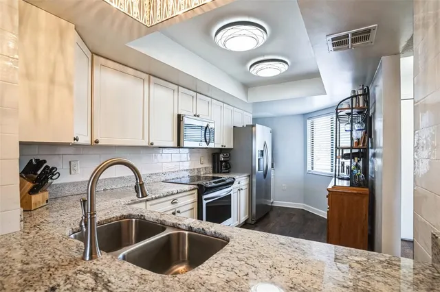 a kitchen with stainless steel appliances granite countertop a sink stove and refrigerator