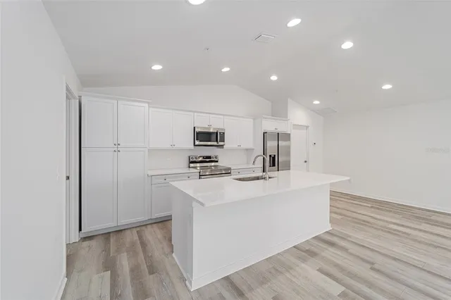 a view of kitchen with sink microwave and refrigerator