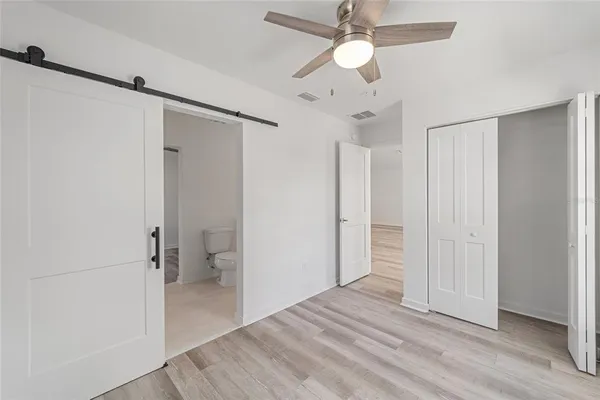 wooden floor in an empty room with a bathroom