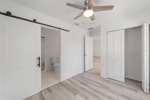 wooden floor in an empty room with a bathroom