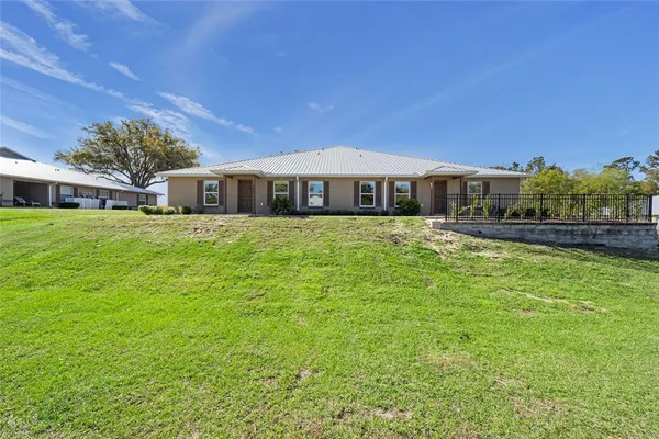 a large house with a big yard and large trees