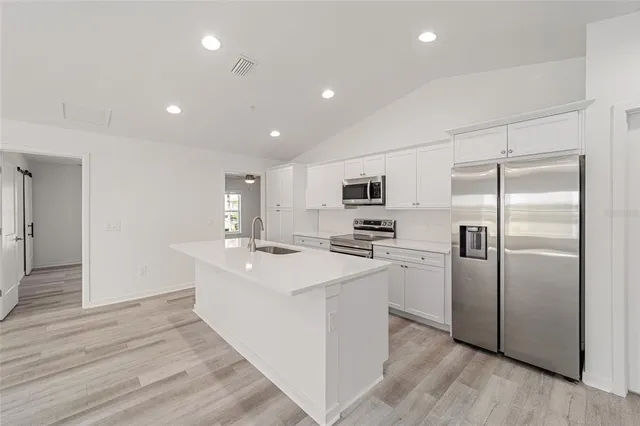 a kitchen with stainless steel appliances a refrigerator sink and stove