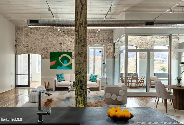 a living room with patio furniture and a floor to ceiling window