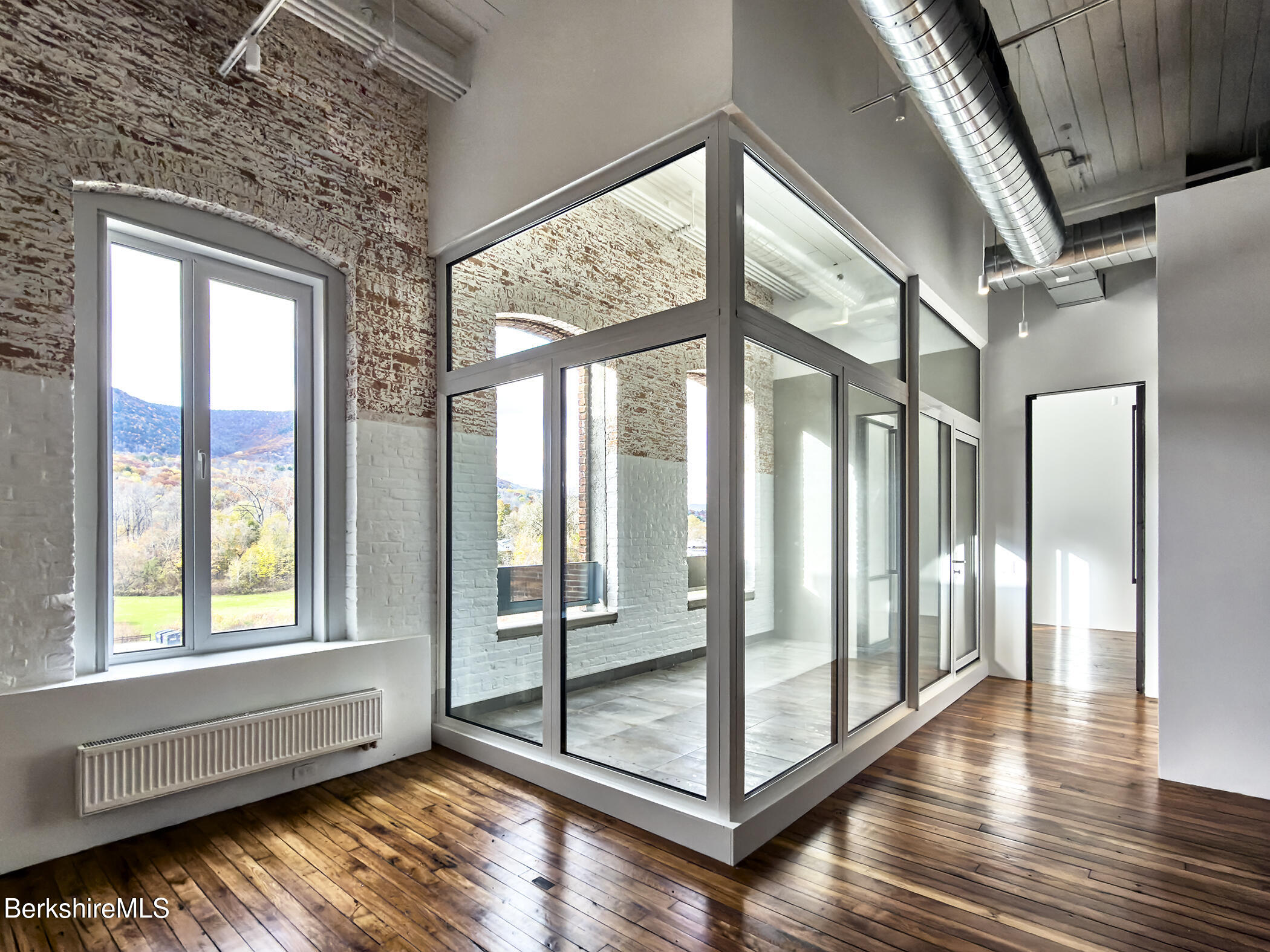 520 State Road, Unit 402 North Adams, MA 01247 - Photo 10 of 22 a view of an empty room with wooden floor and windows