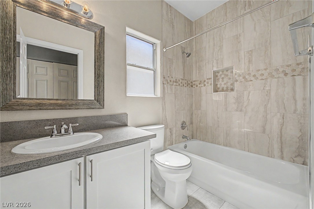 2316 Ramsgate Drive Henderson, NV 89074 - Photo 17 of 28 Tiled bath with modern vanity, offering comfort and refined style.