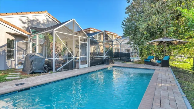 a view of a house with pool and sitting area