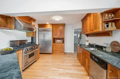 a kitchen with stainless steel appliances granite countertop a stove a sink and a refrigerator