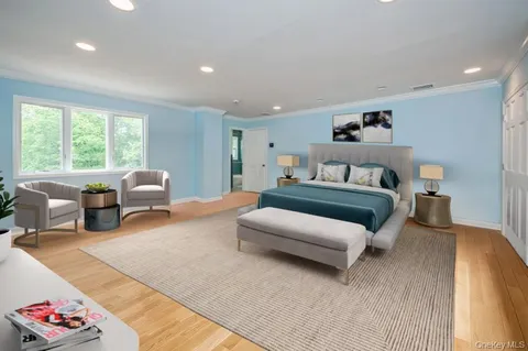 a spacious bedroom with a bed a couch and a large window