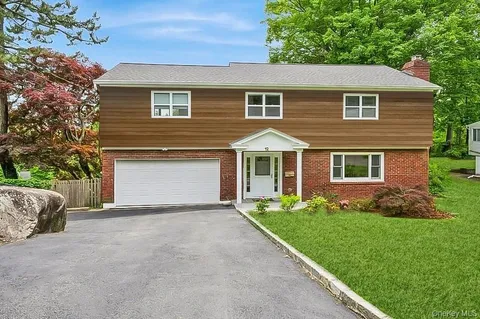 a front view of a house with a garden and yard