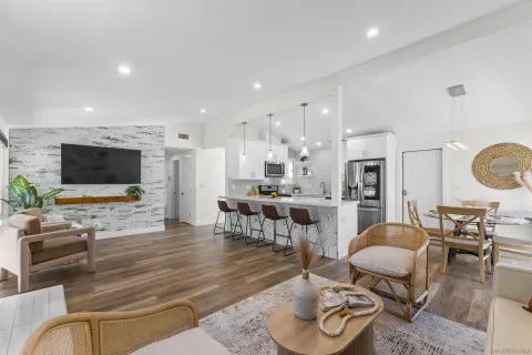 a living room with furniture kitchen view and a flat screen tv