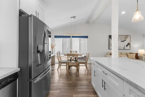 a kitchen with kitchen island a counter top space a sink stainless steel appliances and cabinets