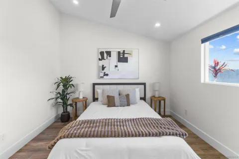 a bedroom with a large bed and a potted plant