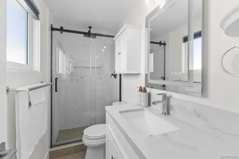 a bathroom with a sink toilet vanity and shower