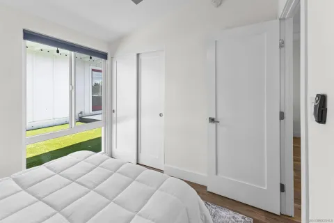 a bedroom with a bed and a large window