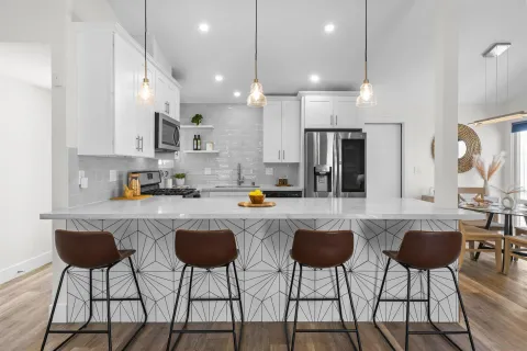 a kitchen with stainless steel appliances a dining table chairs and a refrigerator