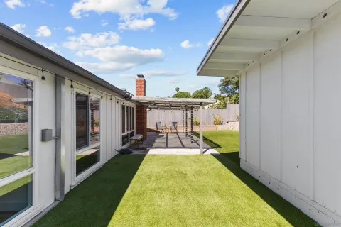 a view of a patio with table and chairs with wooden floor and fence