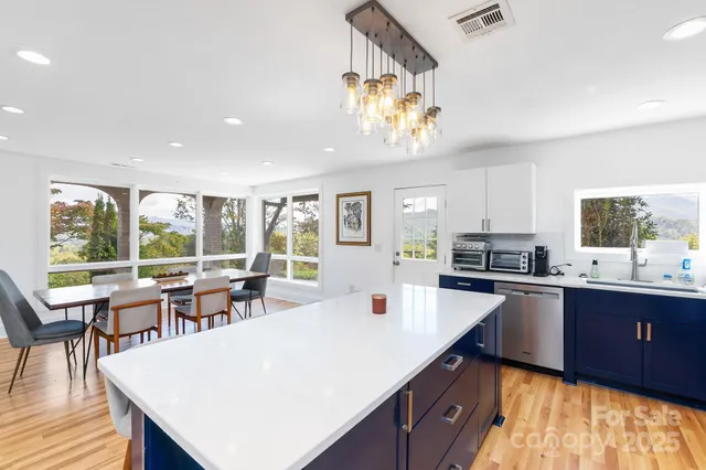 a large kitchen with kitchen island a large island in it